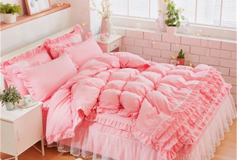 Parure de lit rose saumon à dentelle. Bonne qualité, confortable et à la mode sur un lit dans une maison