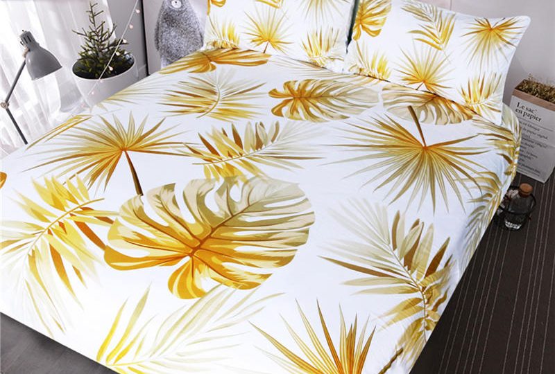 Parure de lit blanche à motif feuilles de palmier jaune. Bonne qualité, confortable et à la mode sur un lit dans une maison