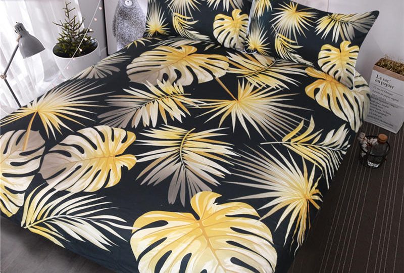 Parure de lit bleu nuit motif feuilles de palmier jaunes. Bonne qualité, confortable et à la mode sur un lit dans une maison