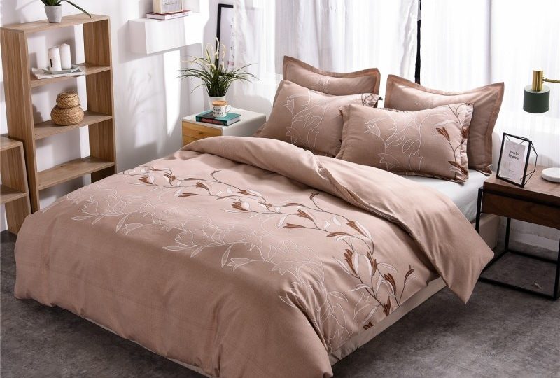 Parure de lit beige à motif floral unique. Bonne qualité, et à la mode sur un lit dans une maison