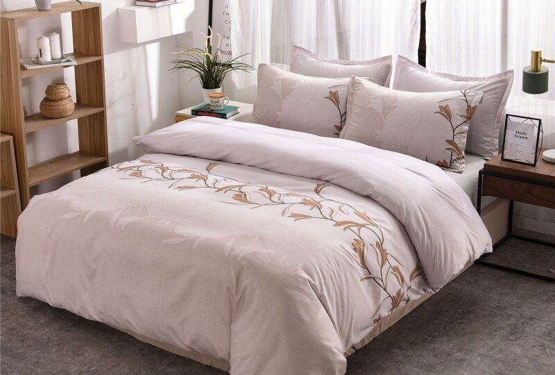 Parure de lit blanche à motif floral unique. Bonne qualité, confortable et à la mode sur un lit dans une maison