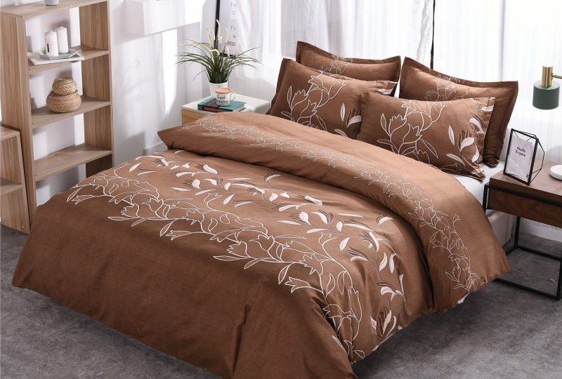 Parure de lit marron à motif floral unique. Bonne qualité et confortable à la mode sur un lit dans une maison