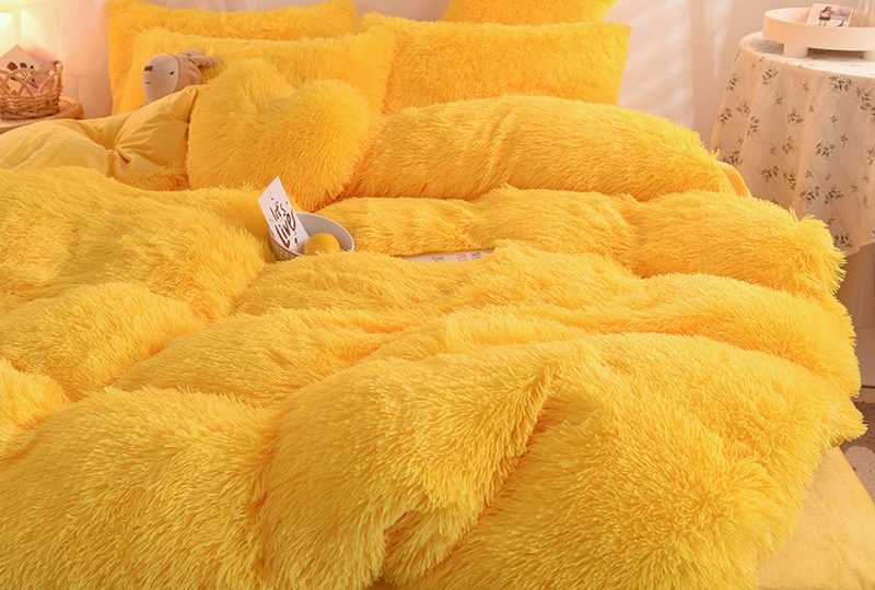 Parure de lit polaire jaune. Bonne qualité, confortable et à la mode sur un lit dans une maison