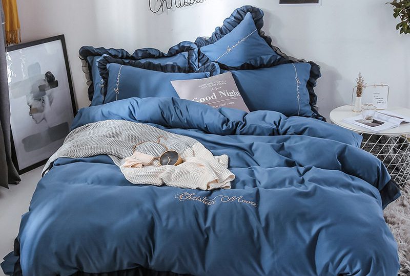 Parure de lit bleu marine contour noir. Bonne qualité, confortable et à la mode sur un lit dans une maison
