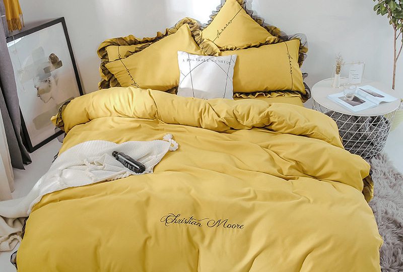 Parure de lit jaune contour marron. Bonne qualité, confortable et à la mode sur un lit dans une maison