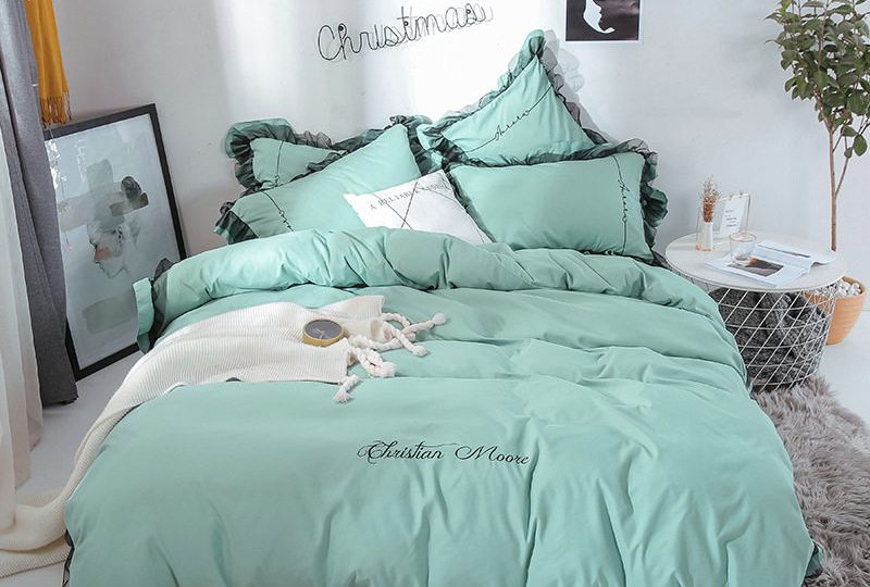 Parure de lit vert menthe contour noir. Bonne qualité, confortable et à la mode sur un lit dans une maison
