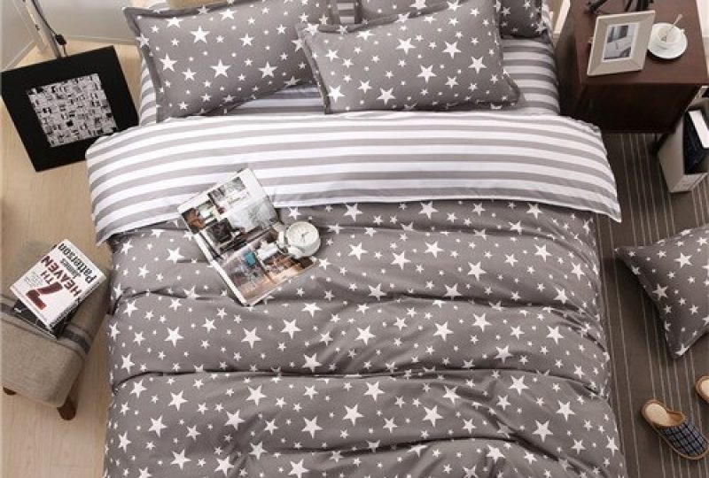 Parure de lit grise avec imprimé étoiles blancs. Bonne qualité, confortable et à a mode sur un lit dans une maison