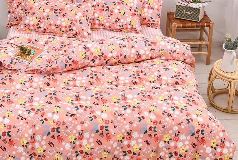Parure de lit rose saumon avec imprimé fleuri. Bonne qualité, confortable et à la mode sur un lit dans une maison