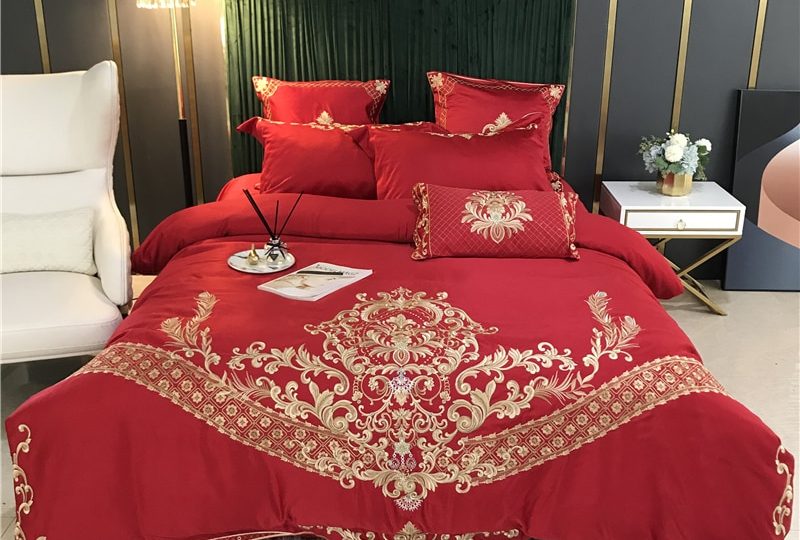 Parure de lit rouge brodée en satin. Bonne qualité, confortable et à la mode sur un lit dans une maison