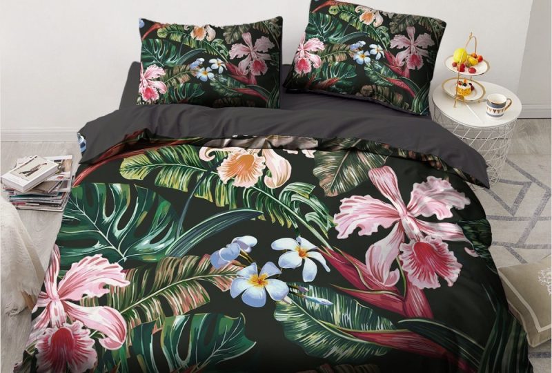 Parure de lit noire à motif fleur tropicale. Bonne confortable et à la mode sur un lit dans une maison