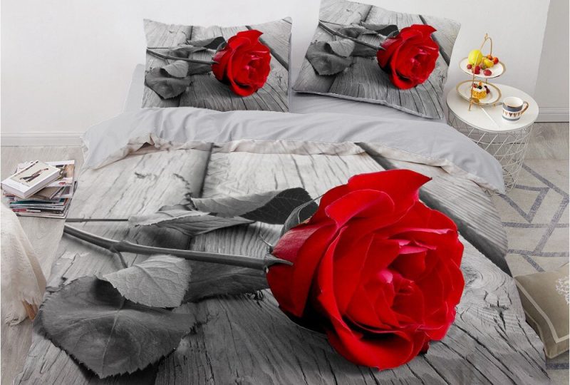 Parure de lit grise avec imprimé fleur rose rouge. Bonne qualité, confortable et à la mode sur un lit dans une maison