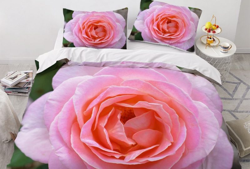 Parure de lit avec imprimé de rose rose. Bonne qualité, confortable et à la mode sur un lit dans une maison