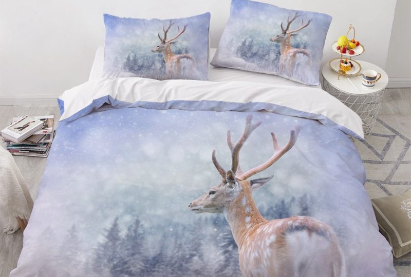 Parure de lit blanche à motif renne sous la neige. Bonne qualité, confortable et à la mode sur un lit dans une maison