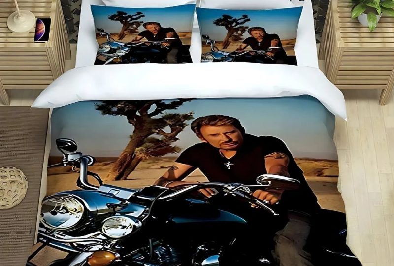 Parure de lit Johnny Hallyday à moto dans un décor avec un arbre et de la terre. Deux coussins assortis à la housse de lit. Posée sur un lit double.