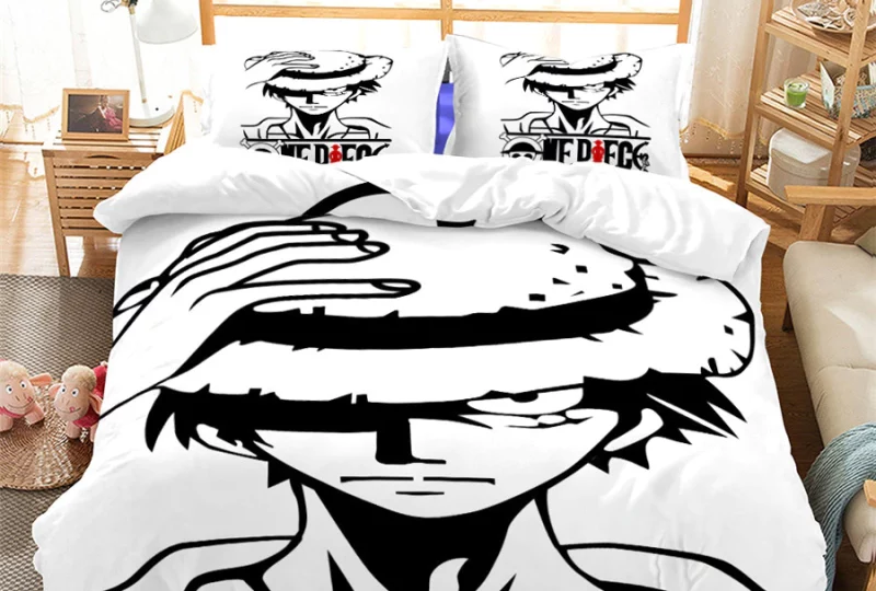 Parure de lit avec deux oreillers avec le même design. On peut y appercevoir Luffy tenant son chapeau. La parure est en noir et blanc.