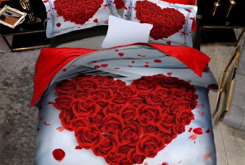 Parure de lit avec un motif de coeur formé par des roses rouge dans une chambre au couleur noir et gris