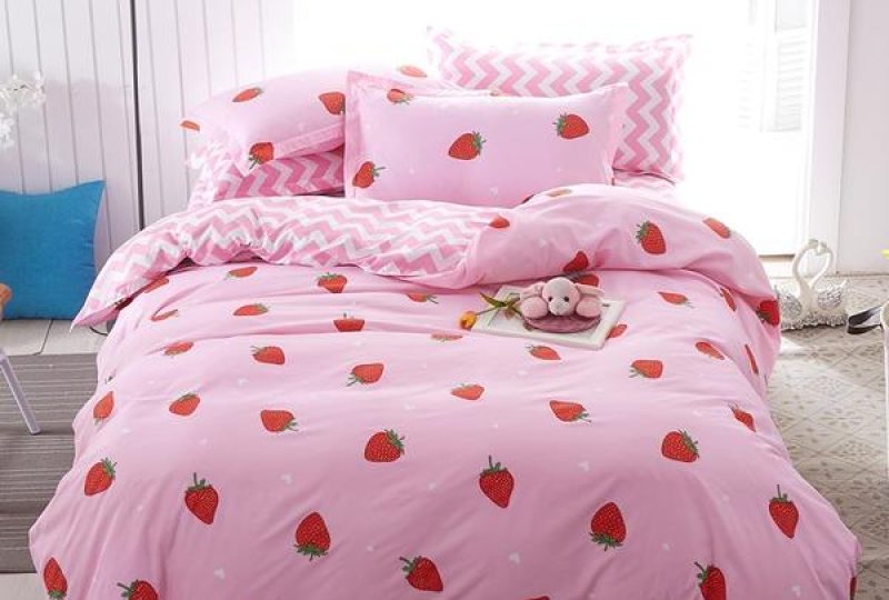 Parure de lit moderne de couleur rose avec des motifs de fraises dans une chambre au style nordique