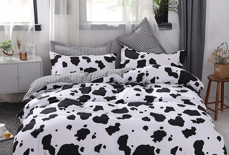 Parure de lit moderne de couleur noir et blanc, au motif vache dans une chambre au style nordique au ton clair