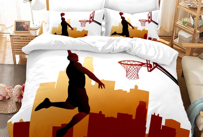 Parure de lit blanche et orange avec la photo de Michael Jordan dont la silhouette est en train de marquer un panier de basket, dans une chambre avec une table de chevet en bois à gauche et un meuble étagère à gauche