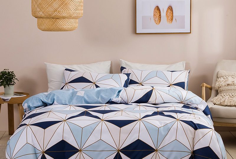 Parure de lit scandinave bleue et blanche installée sur un lit dans une chambre