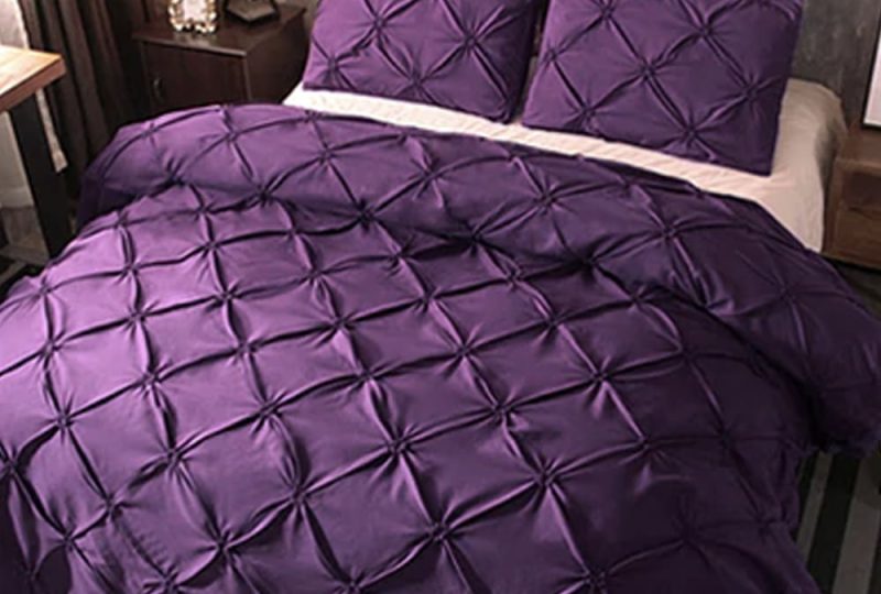 Parure de lit violette à effet matelassé. Bonne qualité et confortable et à la mode sur un lit dans une maison