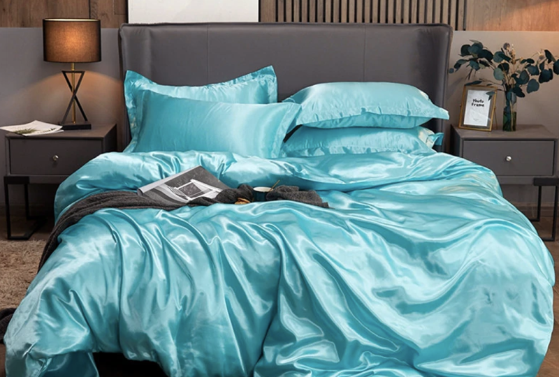 Parure de lit satinée turquoise, bonne qualité, confortable et très à la mode sur un lit dans une maison,